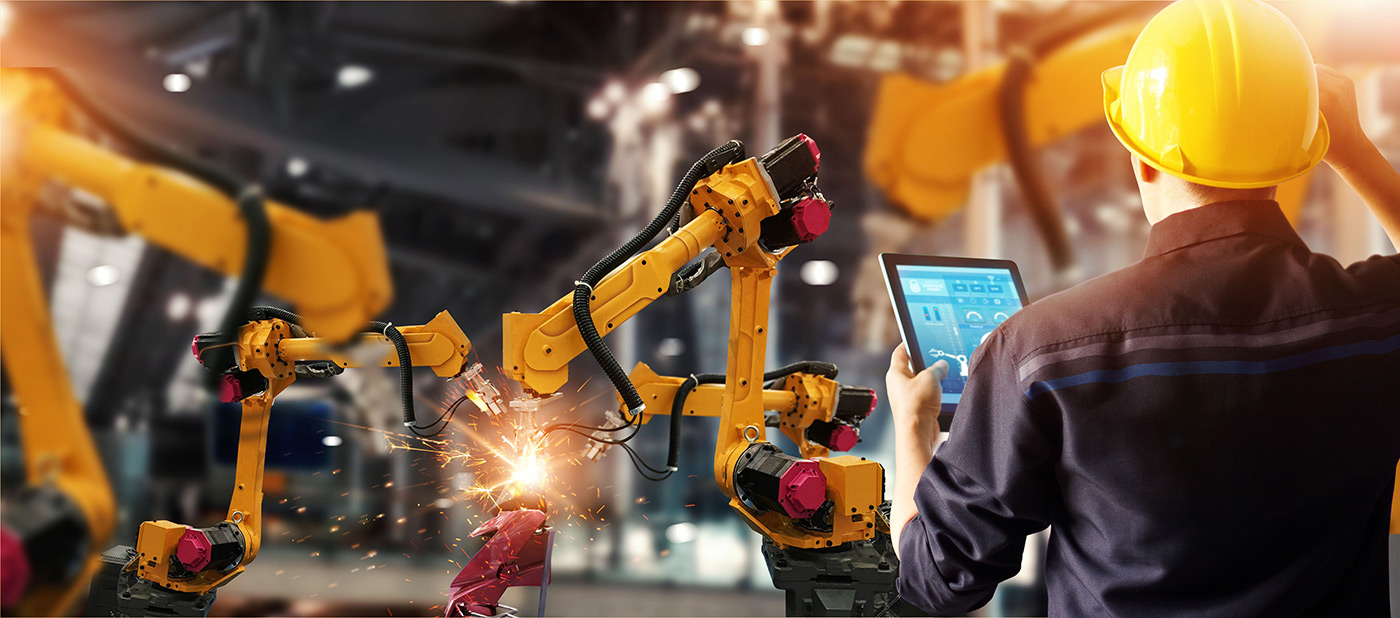 Automation equipment, industrial robots, and an engineer reviewing facility controls